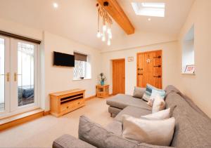 a living room with a couch and a tv at Eva Cottage in West Runton