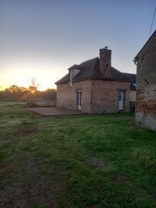een oud stenen huis met de zonsondergang erachter bij Chez Mimi in Trévol