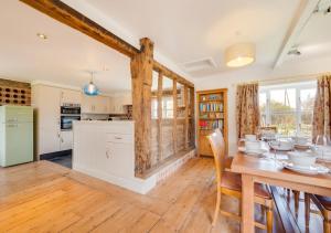 a kitchen and dining room with a wooden table at Mill Farm Barn in Walcott