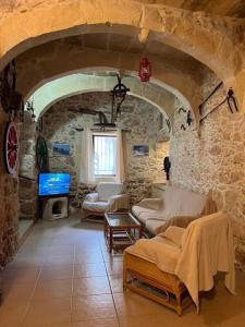 a living room with a room with a stone wall at Brooklyn Farmhouse in Żebbuġ