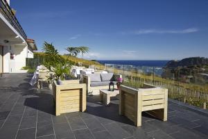 um pátio com mobiliário branco e vista para o oceano em Hotel San Prudentzio em Getaria