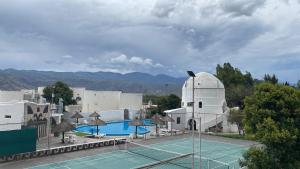 um campo de ténis em frente a um edifício em HOTEL CAASAMA em Santa María