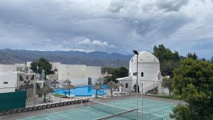 un campo da tennis di fronte a un edificio di HOTEL CAASAMA a Santa María