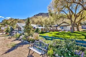 a bench in a garden with flowers and a house at The Historic West Walker Motel in Walker