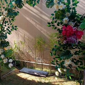 un giardino fiorito con una tavola di legno nell'erba di Casa de Praia Alter do Chão ad Alter do Chão