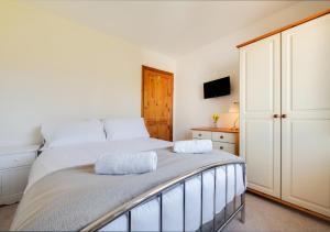 a bedroom with a large bed and a cabinet at Skippers Retreat in Dersingham