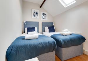 1 dormitorio con 2 camas y almohadas azules en The Old Antique Shop, en Holt