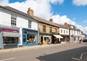 a street in a town with shops and buildings at The Old Antique Shop in Holt
