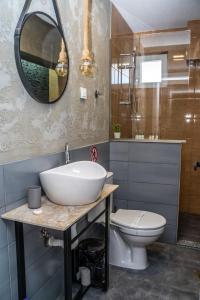 La salle de bains est pourvue d'un lavabo, de toilettes et d'un miroir. dans l'établissement Finesi Apartments 2, à Ohrid