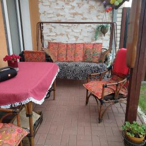 a patio with a table and chairs and a couch at Namelis uždarame kieme in Šiauliai