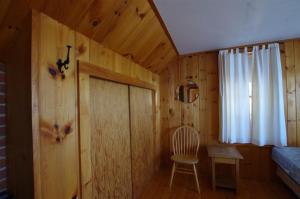 a wooden room with a chair and a window at Rock Fern in Sunapee