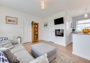 Una sala de estar con un sofá y un televisor. en Rydale Retreat, en Walcott