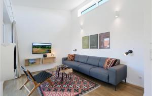 a living room with a couch and a tv at Nice Home In Lembruchdümmer See in Lembruch