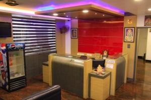 a restaurant with a bar with purple lights at Hotel Sri Hayagriva in Srīrangam
