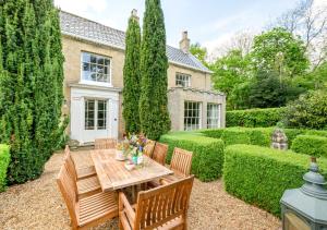 a garden with a wooden table and chairs at Dilham House in Dilham