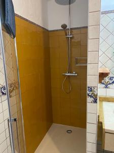 y baño con ducha de azulejos amarillos. en Casas Rurales La Piedra Ossa De Montiel, en Ossa de Montiel