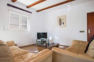 sala de estar con sofá y TV en Villa Noa - PlusHolidays, en Calpe
