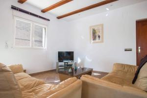 salon z kanapą i telewizorem w obiekcie Villa Noa - PlusHolidays w mieście Calpe