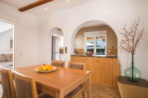 cocina y comedor con mesa de madera en Villa Noa - PlusHolidays, en Calpe