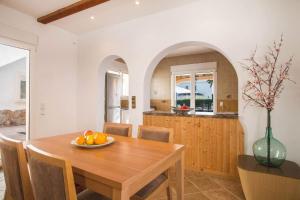 kuchnia i jadalnia z drewnianym stołem w obiekcie Villa Noa - PlusHolidays w mieście Calpe