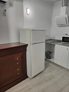 a kitchen with a white refrigerator and a counter at CIH - Constituição Invicta Home in Porto