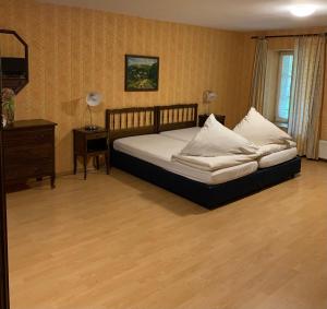 a bedroom with a bed and a dresser and a window at Hotel Restaurant El Greco bei der Taffingsmühle in Saarlouis