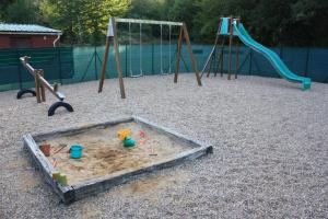 un parque infantil con 2 equipos de juego en la arena en Chalets Moulière Evasion, en Montamisé