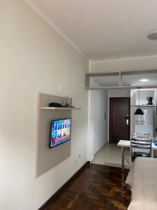 uma sala de estar com uma televisão de ecrã plano na parede em POSIT APARTAMENTOS em Curitiba