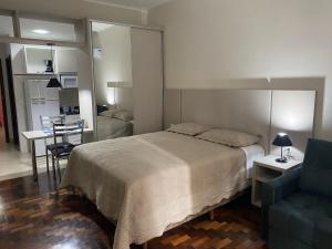 1 dormitorio con 1 cama y 1 sofá azul en POSIT APARTAMENTOS en Curitiba