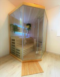 een grote glazen kast in een kamer met een houten vloer bij Sauna en bord de rivière in Morez