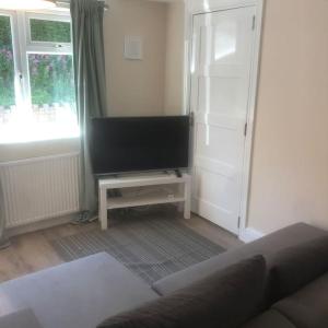 a living room with a couch and a flat screen tv at Quiet and cosy flat, close to Bath Centre in Bath