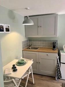 a small kitchen with a table and a sink at Cosy Flat, close to Bath Rugby and City Centre in Bath