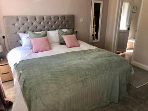 a bedroom with a large bed with two pink pillows at Quiet and cosy flat, close to Bath Centre in Bath