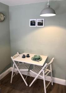 a table with two chairs and a table with a bowl at Cosy Flat, close to Bath Rugby and City Centre in Bath +3 photos