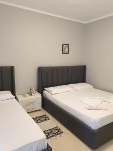 a bedroom with two beds with white sheets at Zeko Apartment in Golem