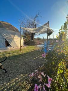 a tent and a table and some flowers at Glamping Salta in Cabra Corral