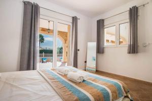 sypialnia z łóżkiem i dużym oknem w obiekcie Villa Noa - PlusHolidays w mieście Calpe