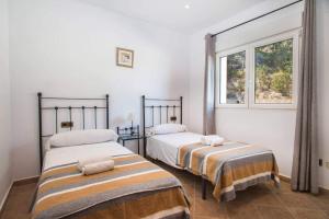 dwa łóżka w pokoju z oknem w obiekcie Villa Noa - PlusHolidays w mieście Calpe +27 zdjęć