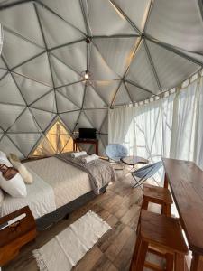 a room with a bed and a table in a tent at Glamping Salta in Coronel Moldes