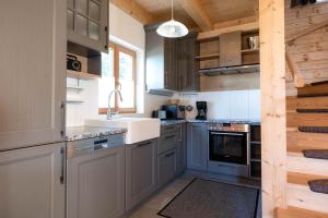 a kitchen with gray cabinets and a sink at Feriendorf Koralpe Wellness Edelweiß in Frantschach