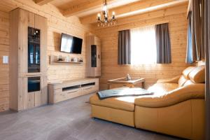 a living room with a couch and a television in a room at Feriendorf Koralpe Wellness Edelweiß in Frantschach