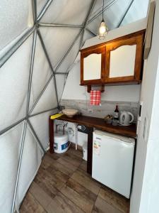 a kitchen in a dome tent with a sink and a refrigerator at Glamping Salta in Coronel Moldes