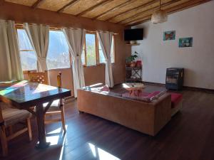 a living room with a couch and a table at Cabaña Canto del Viento, 4 personas in Horcon