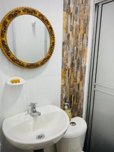 a bathroom with a sink and a mirror on the wall at EcoHotel Brisas del Amani in Norcasia