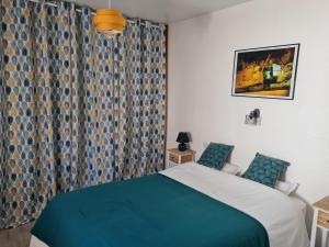 a bedroom with a bed and a window with curtains at Maison de Campagne cosy in Pons