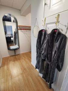 um quarto com casacos pendurados numa parede e um espelho em Relaxing Beatiful Studio - Sauna Bath Facility em Kotka