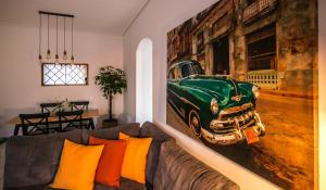 een woonkamer met een bank en een schilderij van een groene auto bij The Coffee House in Tríkala