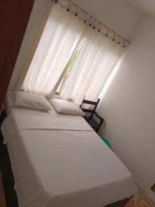 Cama pequeña en habitación con ventana en Hotel San Adolfo Carepa, en Carepa