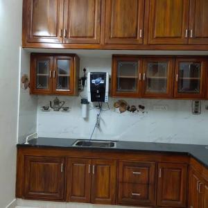 a kitchen with wooden cabinets and a phone on the wall at Sapphire Luxury Apartment in Pondicherry