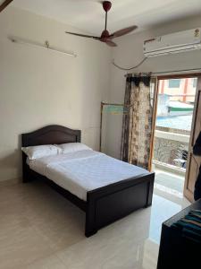 1 dormitorio con 1 cama y ventilador de techo en Sapphire Luxury Apartment en Pondicherry
